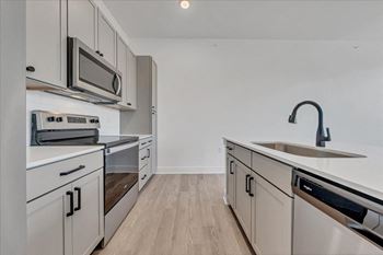 A kitchen with white cabinets and stainless steel appliances.